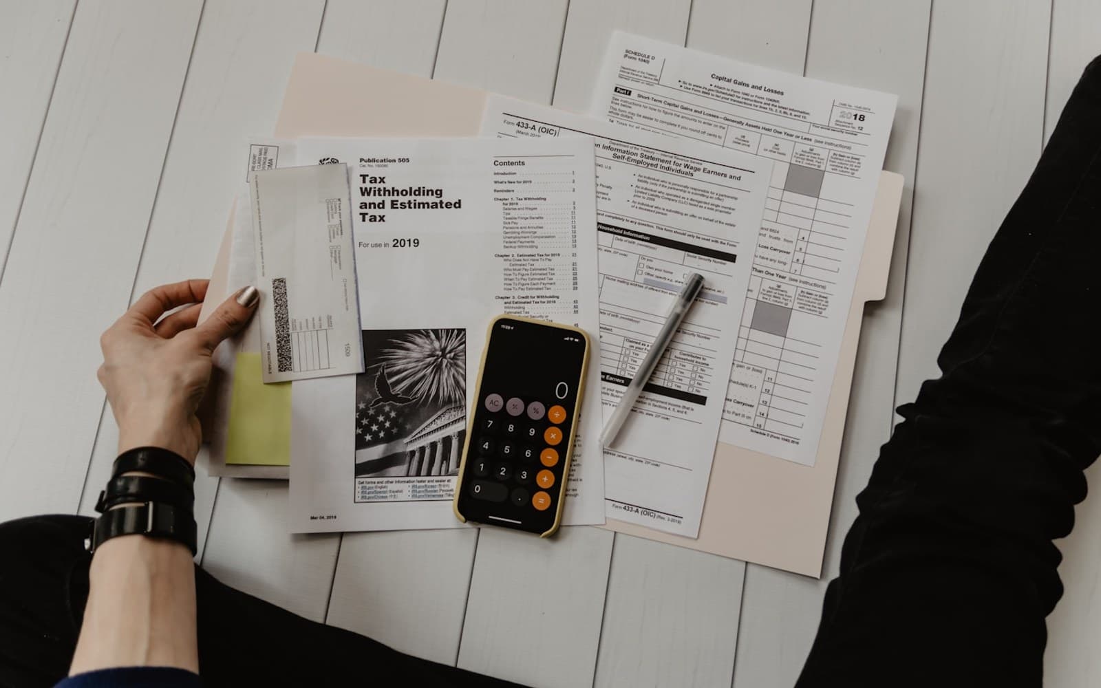 Documentos fiscales, calculadora y bolígrafo sobre una mesa, calculando un presupuesto