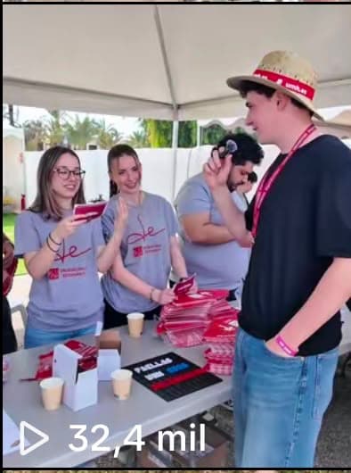 Estudiantes en el puesto de las Fallas UMH repartiendo merchandising